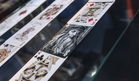 Spielkarten in Reihen unter Glas, Nahaufnahme